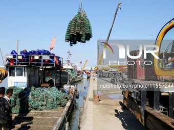 Fishermen hoist oyster cage seedlings for sea release in Lianyungang, China, on September 8, 2024. (