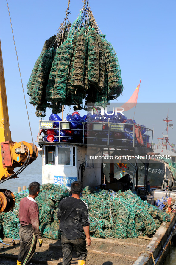 Fishermen hoist oyster cage seedlings for sea release in Lianyungang, China, on September 8, 2024. 