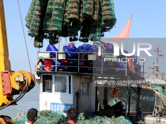 Fishermen hoist oyster cage seedlings for sea release in Lianyungang, China, on September 8, 2024. (