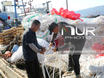 Fishermen load a floating ship to be transported to a breeding area in Lianyungang, China, on September 8, 2024. (