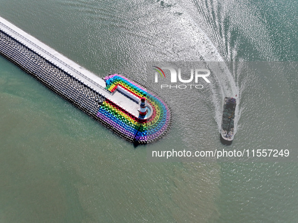 Coastal fishermen drive a fishing boat to transport oyster cage seedlings to a breeding area for spreading and stocking in Lianyungang, Chin...