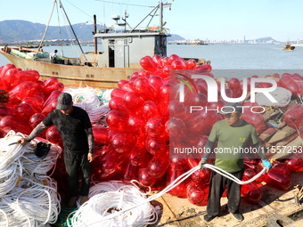 Fishermen load a floating ship to be transported to a breeding area in Lianyungang, China, on September 8, 2024. (