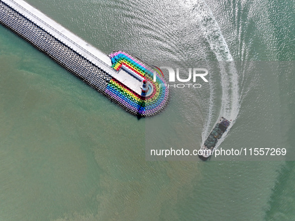 Coastal fishermen drive a fishing boat to transport oyster cage seedlings to a breeding area for spreading and stocking in Lianyungang, Chin...