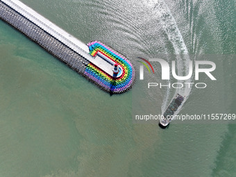 Coastal fishermen drive a fishing boat to transport oyster cage seedlings to a breeding area for spreading and stocking in Lianyungang, Chin...