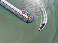 Coastal fishermen drive a fishing boat to transport oyster cage seedlings to a breeding area for spreading and stocking in Lianyungang, Chin...