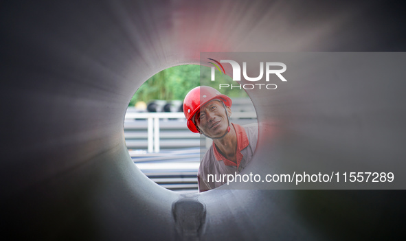 A worker produces pipes at a production workshop in Suqian, China, on September 8, 2024. 