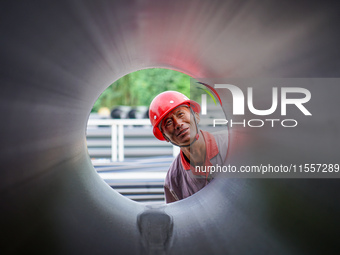 A worker produces pipes at a production workshop in Suqian, China, on September 8, 2024. (