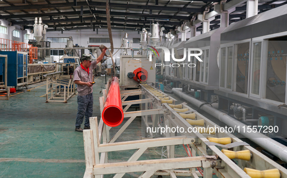 A worker produces pipes at a production workshop in Suqian, China, on September 8, 2024. 