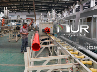 A worker produces pipes at a production workshop in Suqian, China, on September 8, 2024. (