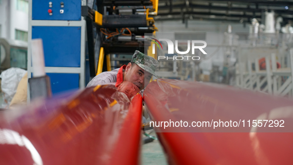 A worker produces pipes at a production workshop in Suqian, China, on September 8, 2024. 