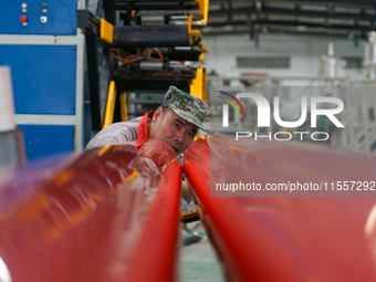 A worker produces pipes at a production workshop in Suqian, China, on September 8, 2024. (