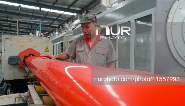 A worker produces pipes at a production workshop in Suqian, China, on September 8, 2024. 