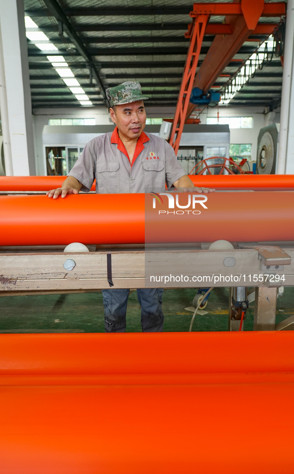 A worker produces pipes at a production workshop in Suqian, China, on September 8, 2024. 