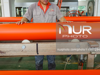 A worker produces pipes at a production workshop in Suqian, China, on September 8, 2024. (