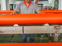 A worker produces pipes at a production workshop in Suqian, China, on September 8, 2024. (