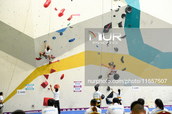 Contestants take part in a rock climbing competition at the indoor climbing gym of Anlong National Mountain Outdoor Sports Demonstration Par...