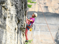 Contestants compete in the Red Dot competition at the Natural Rock Wall of Anlong National Mountain Outdoor Sports Demonstration Park in Qia...