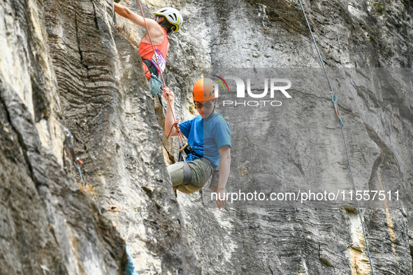 Contestants compete in the Red Dot competition at the Natural Rock Wall of Anlong National Mountain Outdoor Sports Demonstration Park in Qia...