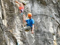 Contestants compete in the Red Dot competition at the Natural Rock Wall of Anlong National Mountain Outdoor Sports Demonstration Park in Qia...