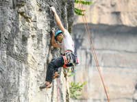 Contestants compete in the Red Dot competition at the Natural Rock Wall of Anlong National Mountain Outdoor Sports Demonstration Park in Qia...