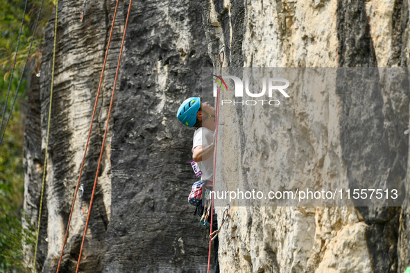 Contestants compete in the Red Dot competition at the Natural Rock Wall of Anlong National Mountain Outdoor Sports Demonstration Park in Qia...