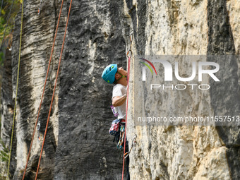 Contestants compete in the Red Dot competition at the Natural Rock Wall of Anlong National Mountain Outdoor Sports Demonstration Park in Qia...