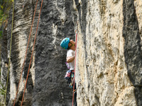 Contestants compete in the Red Dot competition at the Natural Rock Wall of Anlong National Mountain Outdoor Sports Demonstration Park in Qia...