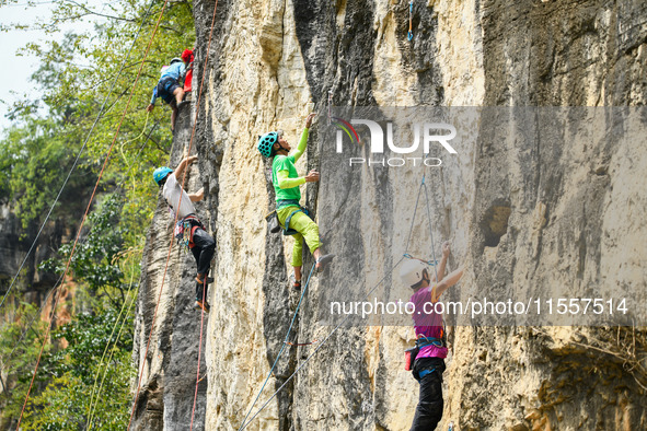 Contestants compete in the Red Dot competition at the Natural Rock Wall of Anlong National Mountain Outdoor Sports Demonstration Park in Qia...