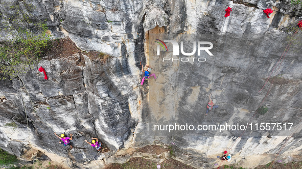 Contestants compete in the Red Dot competition at the Natural Rock Wall of Anlong National Mountain Outdoor Sports Demonstration Park in Qia...