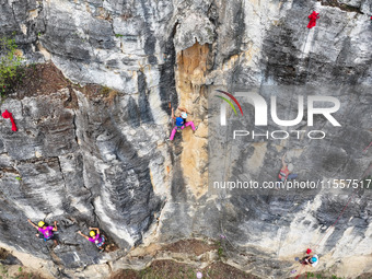 Contestants compete in the Red Dot competition at the Natural Rock Wall of Anlong National Mountain Outdoor Sports Demonstration Park in Qia...