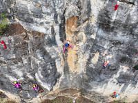 Contestants compete in the Red Dot competition at the Natural Rock Wall of Anlong National Mountain Outdoor Sports Demonstration Park in Qia...