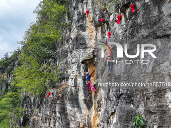 Contestants compete in the Red Dot competition at the Natural Rock Wall of Anlong National Mountain Outdoor Sports Demonstration Park in Qia...