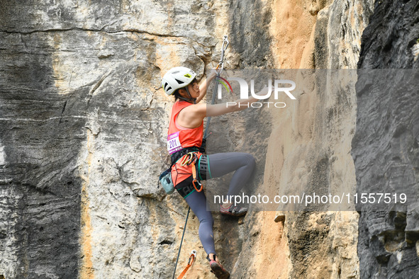 Contestants compete in the Red Dot competition at the Natural Rock Wall of Anlong National Mountain Outdoor Sports Demonstration Park in Qia...