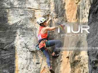 Contestants compete in the Red Dot competition at the Natural Rock Wall of Anlong National Mountain Outdoor Sports Demonstration Park in Qia...