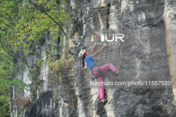 Contestants compete in the Red Dot competition at the Natural Rock Wall of Anlong National Mountain Outdoor Sports Demonstration Park in Qia...