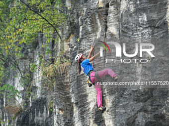 Contestants compete in the Red Dot competition at the Natural Rock Wall of Anlong National Mountain Outdoor Sports Demonstration Park in Qia...