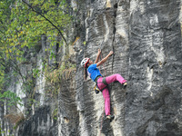 Contestants compete in the Red Dot competition at the Natural Rock Wall of Anlong National Mountain Outdoor Sports Demonstration Park in Qia...