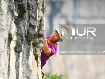 Contestants compete in the Red Dot competition at the Natural Rock Wall of Anlong National Mountain Outdoor Sports Demonstration Park in Qia...