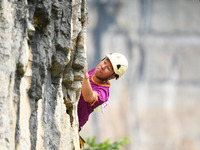 Contestants compete in the Red Dot competition at the Natural Rock Wall of Anlong National Mountain Outdoor Sports Demonstration Park in Qia...