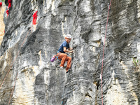 Contestants compete in the Red Dot competition at the Natural Rock Wall of Anlong National Mountain Outdoor Sports Demonstration Park in Qia...