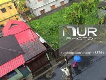 An Indian woman uses an umbrella during a rainfall in Siliguri, India, on September 8, 2024. (