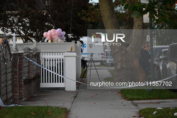 Crime scene investigators place evidence markers at the scene where three people are shot at 132-45 220th Street in Queens, New York, United...