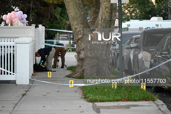 Crime scene investigators place evidence markers at the scene where three people are shot at 132-45 220th Street in Queens, New York, United...