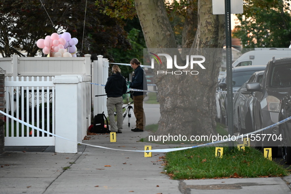 Crime scene investigators place evidence markers at the scene where three people are shot at 132-45 220th Street in Queens, New York, United...