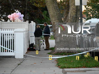 Crime scene investigators place evidence markers at the scene where three people are shot at 132-45 220th Street in Queens, New York, United...