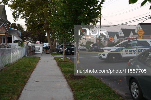 Crime scene investigators place evidence markers at the scene where three people are shot at 132-45 220th Street in Queens, New York, United...