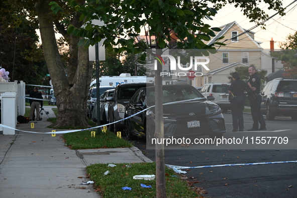 Crime scene investigators place evidence markers at the scene where three people are shot at 132-45 220th Street in Queens, New York, United...