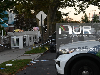 Crime scene investigators place evidence markers at the scene where three people are shot at 132-45 220th Street in Queens, New York, United...