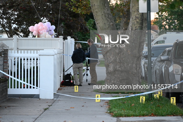 Crime scene investigators place evidence markers at the scene where three people are shot at 132-45 220th Street in Queens, New York, United...