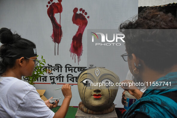 Renowned artist Sanatan Dinda paints the head of a Durga idol with his own artistic expression towards the protest against the rape and murd...